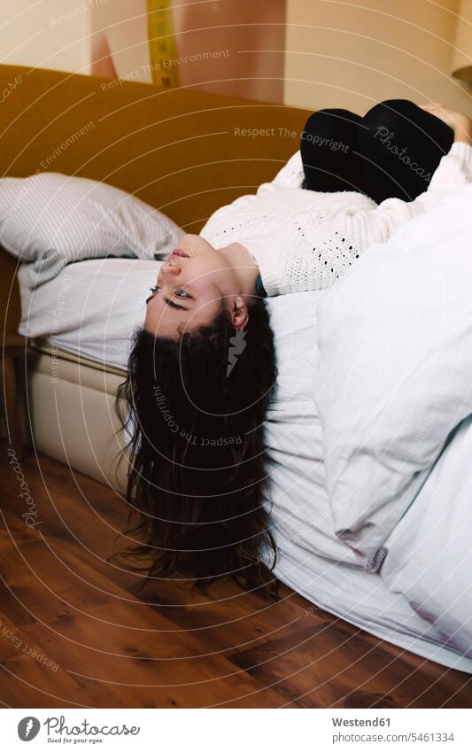 Porträt eines nachdenklichen Mädchens, das auf dem Bett liegt und in die Ferne schaut Betten allein vereinsamt zurueckgezogen zurückgezogen gelangweilt