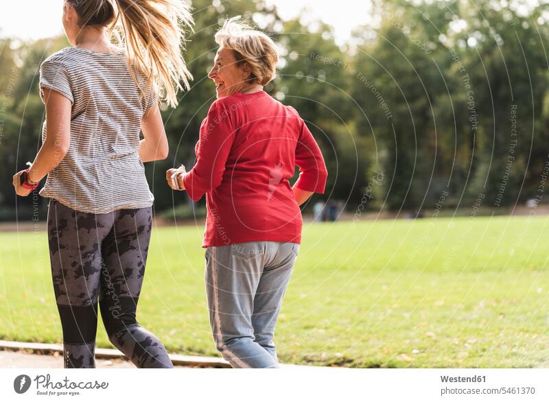 Enkelin und Großmutter haben Spaß, joggen zusammen im Park Gemeinsam Zusammen Miteinander Parkanlagen Parks Joggen Jogging Grossmutter Oma Grossmama Großmütter