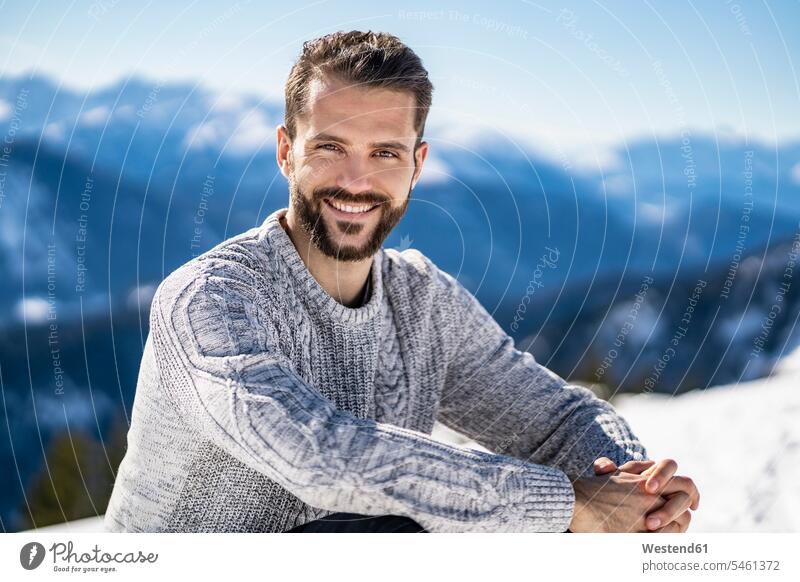 Deutschland, Bayern, Brauneck, Porträt eines lächelnden Mannes im Winter in den Bergen winterlich Winterzeit Portrait Porträts Portraits Männer männlich