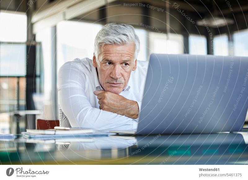 Geschäftsmann sitzt am Schreibtisch und versucht, ein Problem zu lösen Probleme Problematik Schwierigkeiten problematisch Laptop benutzen Laptop benützen