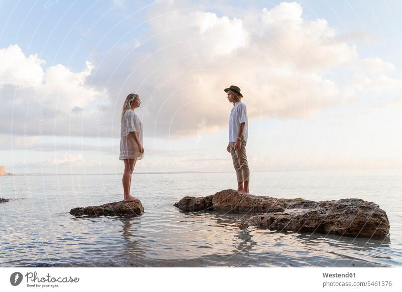 Auf Felsen vor dem Meer stehendes junges Paar, Ibiza, Balearen, Spanien Leute Menschen People Person Personen Europäisch Kaukasier kaukasisch 2 2 Menschen