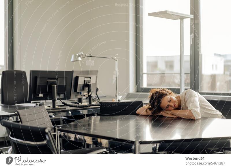 Müde Geschäftsfrau schläft auf ihrem Schreibtisch müde abgespannt Nickerchen Nickerchen machen Geschäftsfrauen Businesswomen Businessfrauen Businesswoman sitzen
