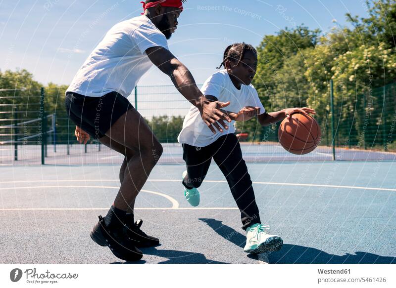 Vater und Sohn spielen Basketball auf dem Basketballfeld Bälle Muße Miteinander Zusammen Anreiz Ansporn Antrieb motivieren motiviert Dynamik trainieren