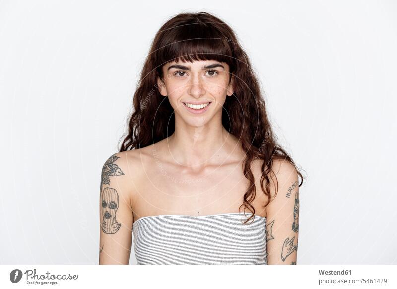 Porträt einer lächelnden jungen Frau mit Sommersprossen und Tattoos auf den Oberarmen schulterfrei nackte Schultern Wort Woerter Worte Wörter