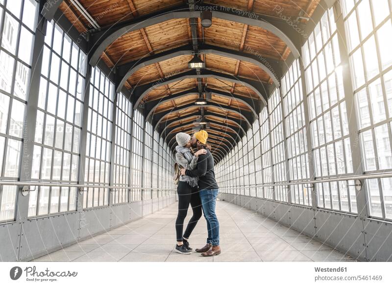 Junges Paar küsst sich in einer U-Bahn-Station, Berlin, Deutschland Touristen Glasscheiben Kuss Küsse verreisen Arm umlegen Umarmung Umarmungen Jahreszeiten