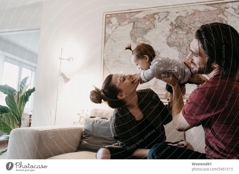 Glückliche Familie spielt mit Baby-Mädchen im Wohnzimmer zu Hause glücklich glücklich sein glücklichsein Zuhause daheim Familien Babies Babys Säuglinge Kind