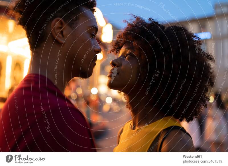 Liebevolles junges Touristenpaar an einem beleuchteten Karussell in der Stadt in der Abenddämmerung, Florenz, Italien Leute Menschen People Person Personen