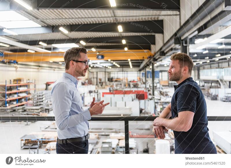 Zwei Männer unterhalten sich in der Fabrikhalle sprechen reden Produktionshalle Montagehalle Fabriken Mann männlich Kollegen Arbeitskollegen Erwachsener