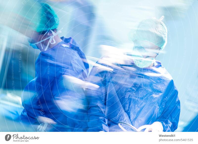 Männliche Ärzte bei einer Operation im Operationssaal eines Krankenhauses Farbaufnahme Farbe Farbfoto Farbphoto Innenaufnahme Innenaufnahmen innen drinnen