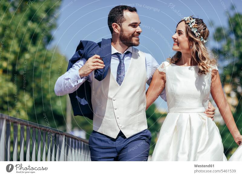 Glückliches Brautpaar, das seinen Hochzeitstag in einem Park genießt Parkanlagen Parks glücklich glücklich sein glücklichsein Brautleute Brautpaare Ehepaar