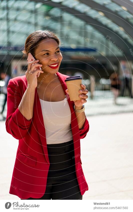 Porträt einer lächelnden Geschäftsfrau mit Kaffee zum Telefonieren, London, UK Leute Menschen People Person Personen Afrikanisch Afrikanische Abstammung
