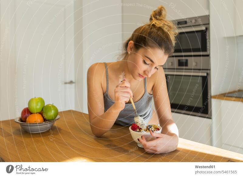 Weiblicher Teenager beim Frühstück in der Küche Schale Schalen Schälchen Schüsseln früh Frühe Morgen hungrig gelangweilt langweilig daheim zu Hause Muße