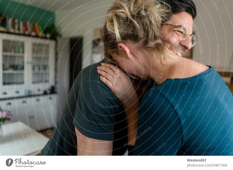 Glückliches Paar umarmt sich zu Hause in der Küche Brillen Arm umlegen Umarmung Umarmungen freuen Frohsinn Fröhlichkeit Heiterkeit glücklich sein glücklichsein