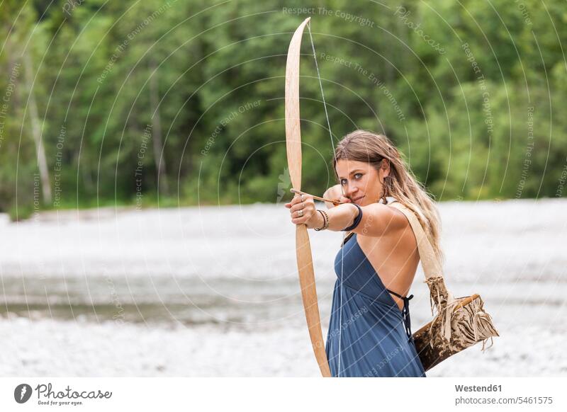 Bogenschützin zielt mit einem Bogen in die Natur zielen zielend Frau weiblich Frauen Bogenschützinnen Bogenschuetzin Bogenschuetzinnen Boegen Bögen Erwachsener