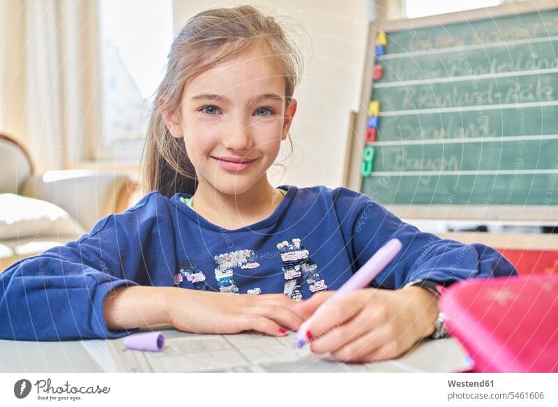 Kleines Mädchen lernt zu Hause Ausbildung Schueler Schulkinder Schüler Schultafel Schultafeln Stifte aufschreiben notieren schreibend Schrift sitzend sitzt