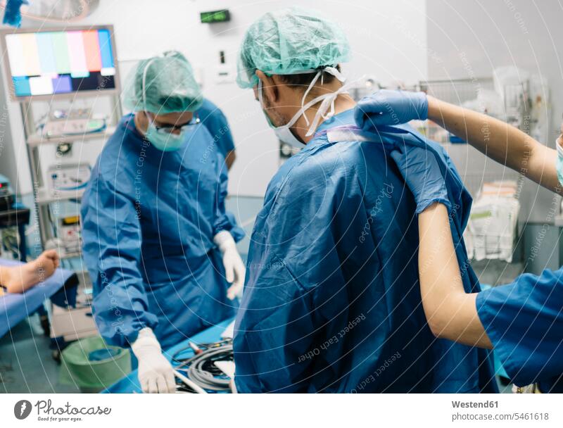 Weiblicher Arzt hilft orthopädischen Chirurgen im Operationssaal im Krankenhaus Farbaufnahme Farbe Farbfoto Farbphoto Innenaufnahme Innenaufnahmen innen drinnen