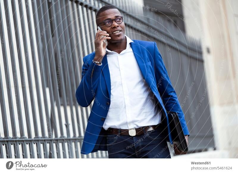 Junger Geschäftsmann in blauer Anzugsjacke und mit Smartphone geschäftlich Geschäftsleben Geschäftswelt Geschäftsperson Geschäftspersonen Businessmann