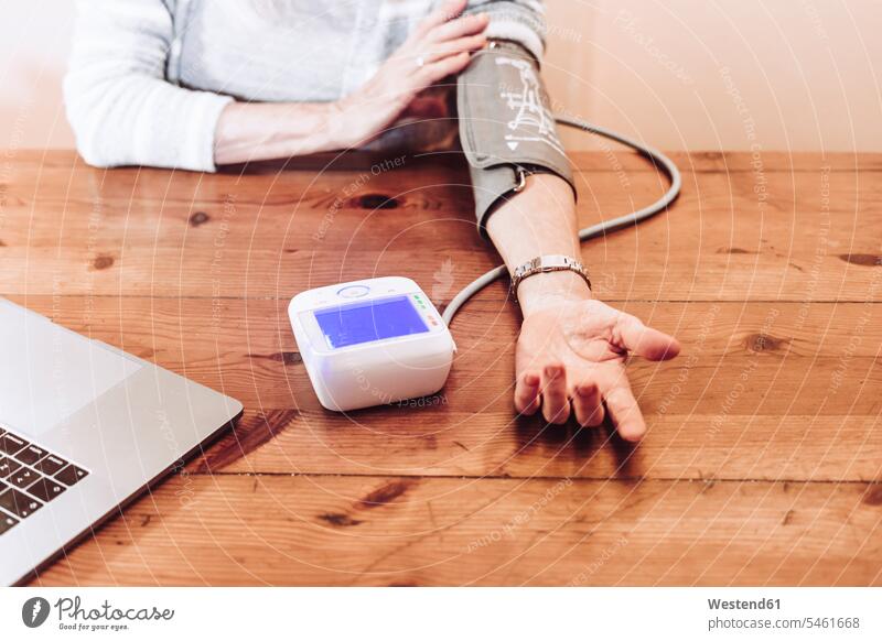 Ältere Frau prüft Blutdruck zu Hause Farbaufnahme Farbe Farbfoto Farbphoto Innenaufnahme Innenaufnahmen innen drinnen Spanien Blutdruckmesser Blutdruckmessgerät