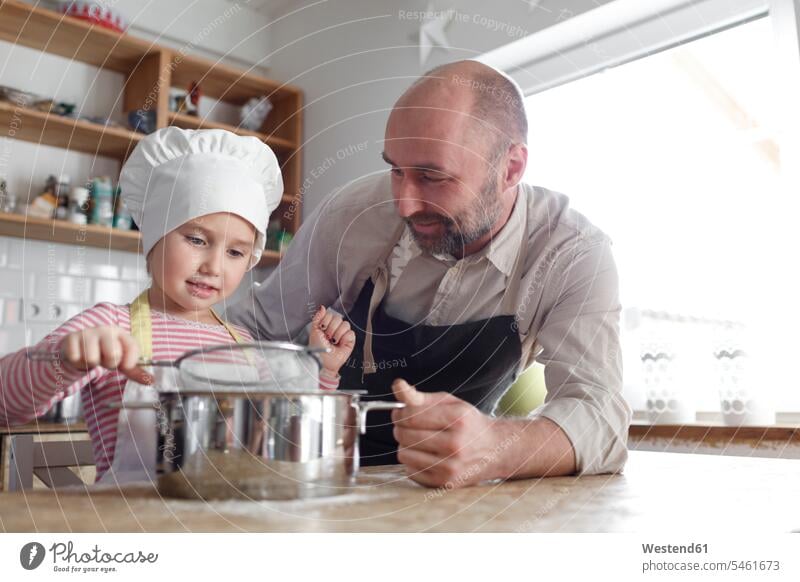 Vater und Tochter kochen in der Küche Kochtoepfe Kochtöpfe Topf Töpfe freuen Glück glücklich sein glücklichsein leidenschaftlich Leidenschaftlichkeit zufrieden
