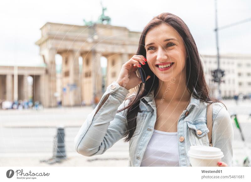 Glückliche junge Frau am Telefon am Brandenburger Tor, Berlin, Deutschland Leute Menschen People Person Personen Europäisch Kaukasier kaukasisch erwachsen