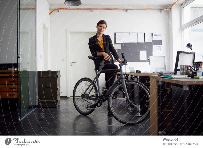 Geschäftsfrau mit Fahrrad in ihrem Start-up-Unternehmen Firmengründerin Gründerinnen Firmengründerinnen Geschäftsfrauen Businesswomen Businessfrauen