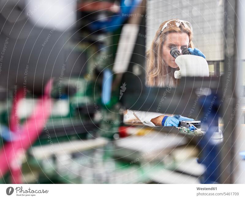 Weibliche Technikerin, die im Forschungslabor mit dem Mikroskop arbeitet Ingenieurin Ingenieurinnen arbeiten Arbeit Platine Platinen Technikerinnen Beruf