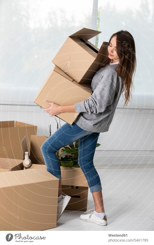 Frau trägt Kartons ins neue Zuhause Pappkartons tragen transportieren Wohnung Mietwohnungen wohnen weiblich Frauen zu Hause daheim Umzug umziehen Erwachsener