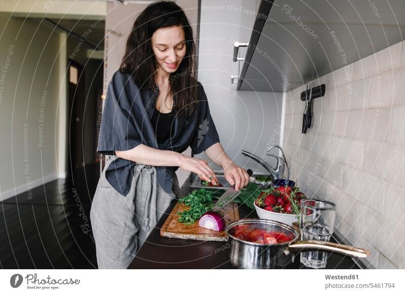 Lächelnde Frau bereitet in der Küche Salat zu Schale Schalen Schälchen Schüsseln freuen zufrieden stehend steht daheim zu Hause Muße alltäglich Essen