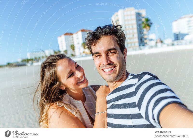 Selfie eines glücklichen jungen Paares am Strand Glück glücklich sein glücklichsein Pärchen Partnerschaft Selfies Beach Straende Strände Beaches Mensch Menschen
