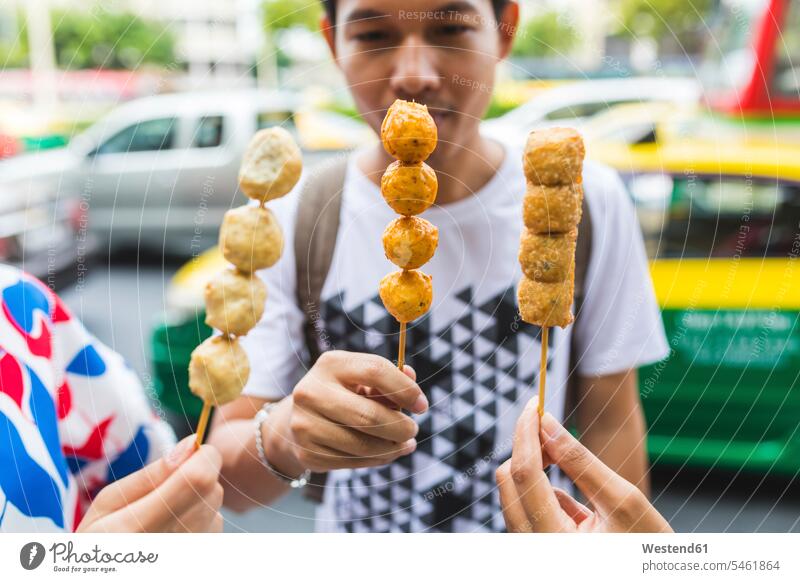 Thailand, Bangkok, Gruppe von Freunden beim Essen auf der Strasse, Nahaufnahme Streetfood Street Food essen essend Freundschaft Kameradschaft Food and Drink
