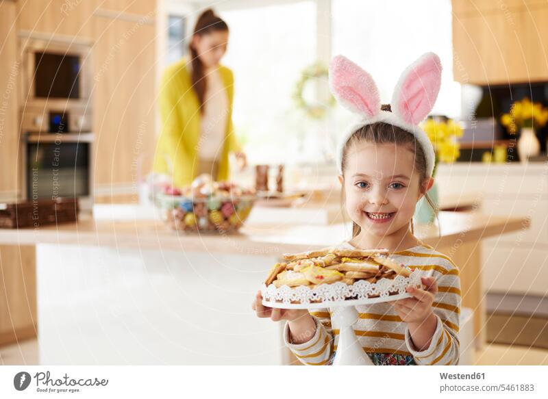 Porträt eines lächelnden Mädchens mit Hasenohren, das Kekse serviert Häschenohren Plaetzchen Plätzchen servieren Portrait Porträts Portraits weiblich Gebäck