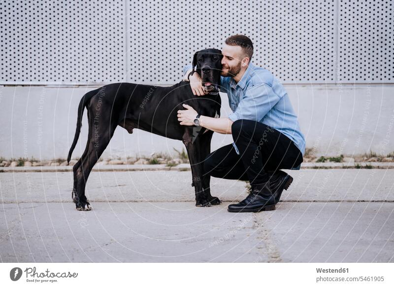 Glücklicher junger Mann kuschelt mit seinem Hund im Freien Leute Menschen People Person Personen Europäisch Kaukasier kaukasisch 1 Ein ein Mensch