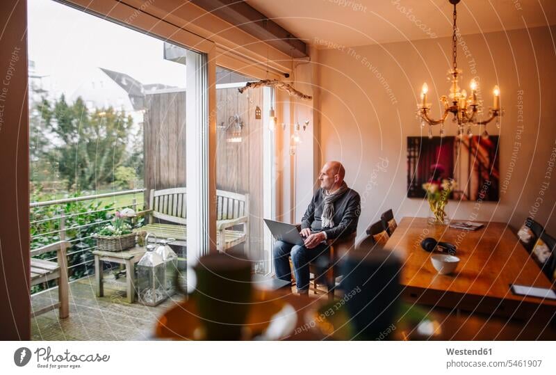 Älterer Mann sitzt zu Hause und benutzt Laptop Europäer Kaukasier Europäisch kaukasisch Balkon Balkone Drahtlose Technologie drahtlose Verbindung