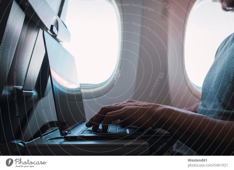 Mann benutzt Laptop im Flugzeug benutzen benützen sitzen sitzend sitzt Notebook Laptops Notebooks Computer Rechner Europäer Kaukasier Europäisch kaukasisch