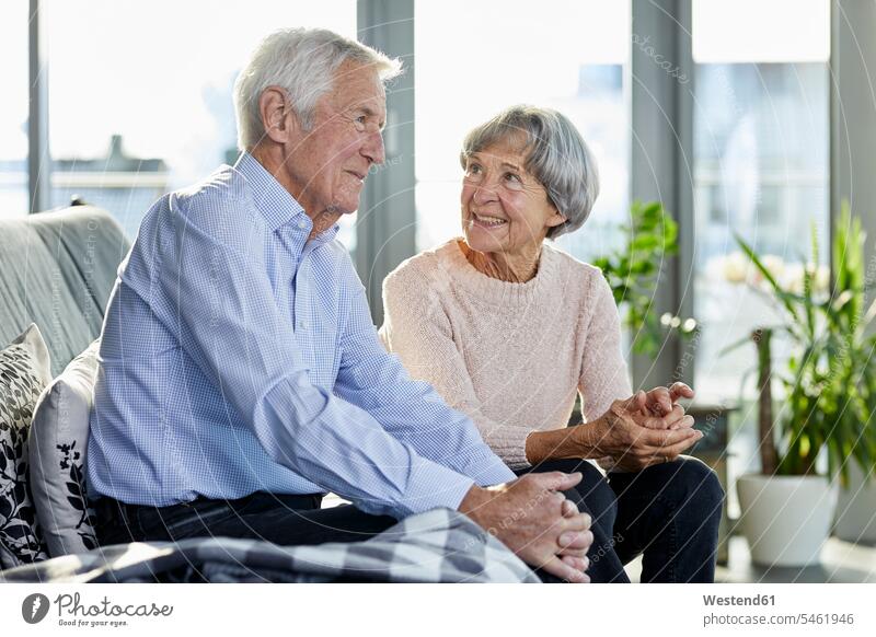 Älteres Paar sitzt auf der Couch und spricht miteinander Sofa Couches Liege Sofas Gemeinsam Zusammen Miteinander Pärchen Paare Partnerschaft Seniorenpaar