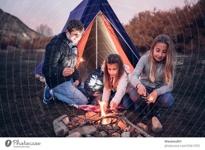Gruppe von vier Kindern beim Zelten abends freuen Campen zelten Flammen Erlebnisse frei Muße Miteinander Zusammen auf Achse in Bewegung Bindung Gemeinschaft