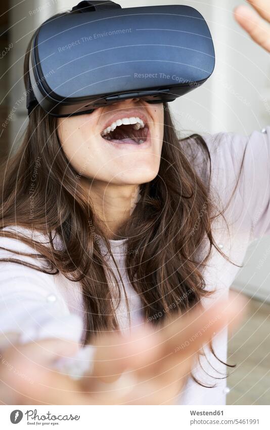 Junge Frau hat Spaß mit Virtual-Reality-Headsets zu Hause Zuhause daheim benutzen interaktiv Interaktivität Virtual Reality Brille Virtual-Reality-Brille