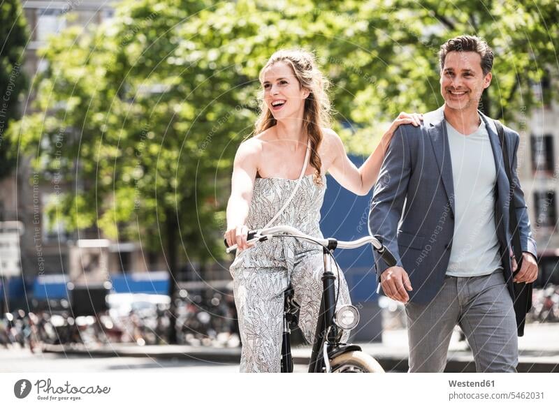 Glückliches Paar mit Fahrrad in der Stadt staedtisch städtisch Bikes Fahrräder Räder Rad Pärchen Paare Partnerschaft glücklich glücklich sein glücklichsein