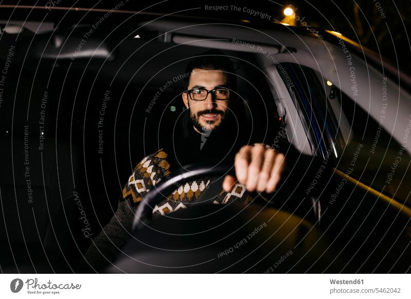 Porträt eines selbstbewussten Mannes beim Autofahren in der Nacht autofahren Portrait Porträts Portraits Zuversicht Zuversichtlich Selbstvertrauen Vertrauen