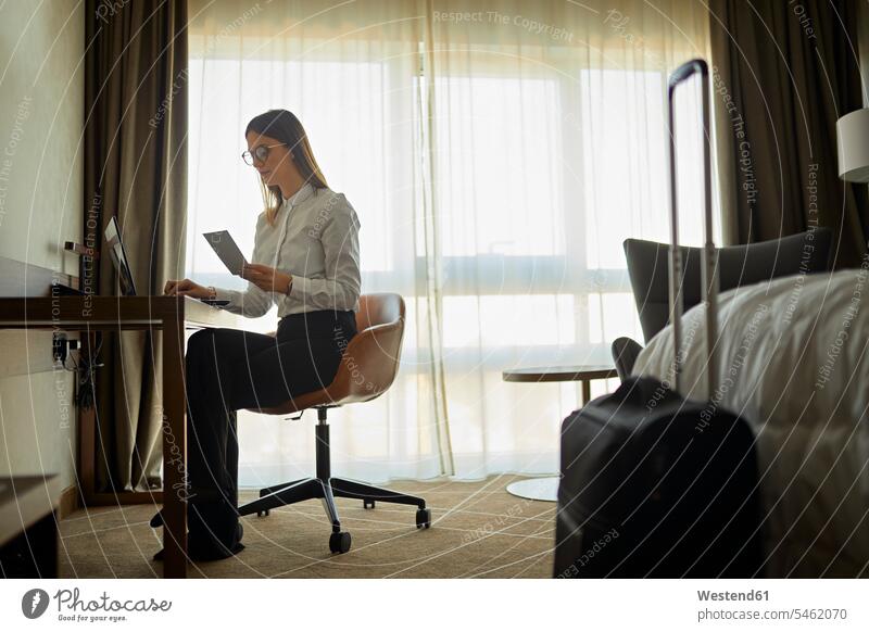 Geschäftsfrau sitzt mit Laptop am Schreibtisch im Hotelzimmer Job Berufe Berufstätigkeit Beschäftigung Jobs geschäftlich Geschäftsleben Geschäftswelt