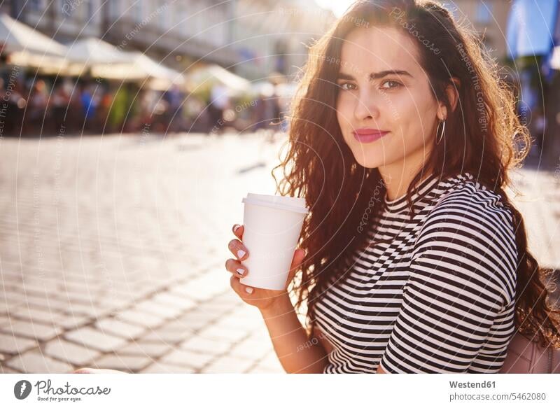 Porträt einer schönen jungen Frau mit Kaffee zum Mitnehmen in der Stadt Portrait Porträts Portraits staedtisch städtisch weiblich Frauen Getränk Getraenk