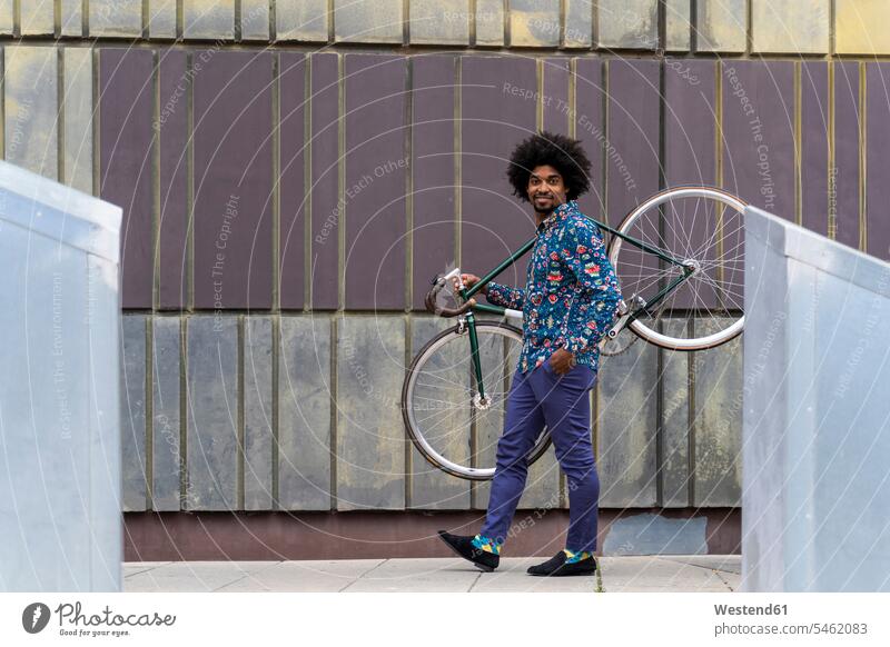Stilvoller Mann mit Fahrrad in der Stadt Hemden Raeder Räder Bike Bikes Fahrräder Rad Rennräder gehend geht zufrieden Farben Farbtoene Farbton Farbtöne blaue