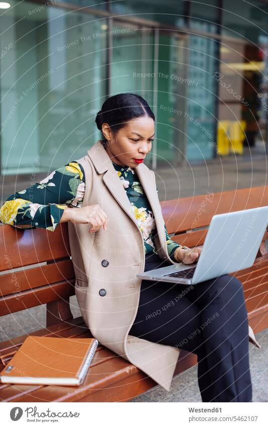 Geschäftsfrau sitzt mit Laptop auf der Bank benutzen benützen Sitzbänke Bänke Sitzbank Geschäftsfrauen Businesswomen Businessfrauen Businesswoman sitzen sitzend