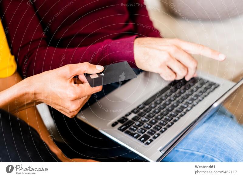 Nahaufnahme eines Paares beim Online-Shopping zu Hause mit Laptop und Kreditkarte Banksystem Banksysteme Bankwesen EC-Karte Kreditkarten Karten Chips