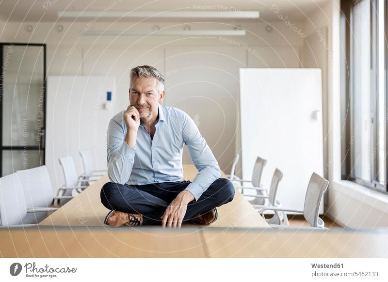 Porträt eines selbstbewussten, reifen Geschäftsmannes, der im Konferenzraum am Tisch sitzt Job Berufe Berufstätigkeit Beschäftigung Jobs geschäftlich
