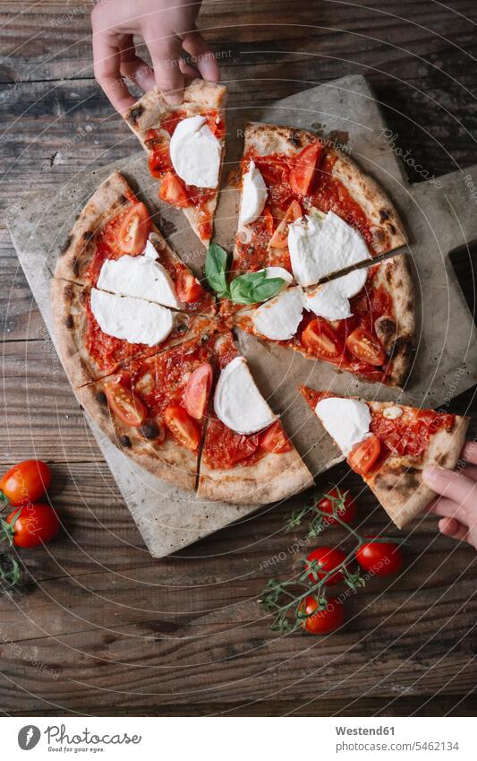 Essen einer Pizza mit Mozzarella, Hand nimmt Pizzastück essen essend Hände Pizzen Pizzastücke nehmen aufnehmen Mensch Menschen Leute People Personen Food