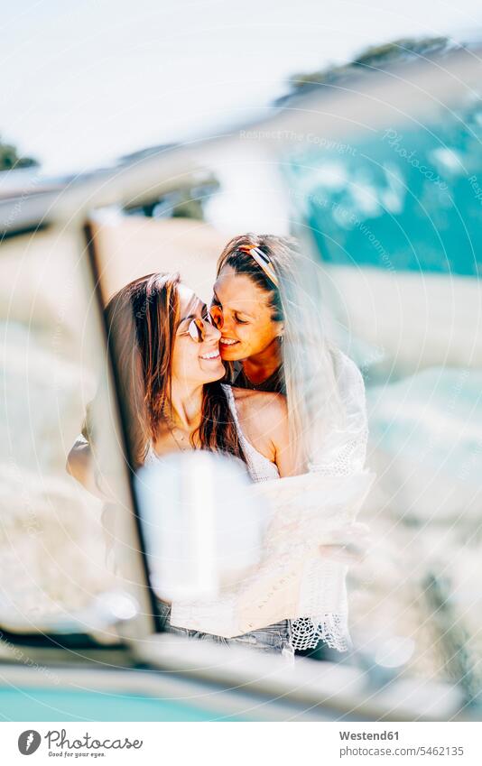Lesbisches Paar macht einen Road Trip, küssen und umarmen in der Natur Pärchen Paare Partnerschaft Lesbe Lesben lesbisch Küsse Kuss Sommer Sommerzeit sommerlich