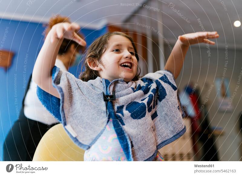 Verspieltes Mädchen mit Handtuch gestikuliert im Friseursalon Farbaufnahme Farbe Farbfoto Farbphoto Spanien Innenaufnahme Innenaufnahmen innen drinnen 4-5 Jahre