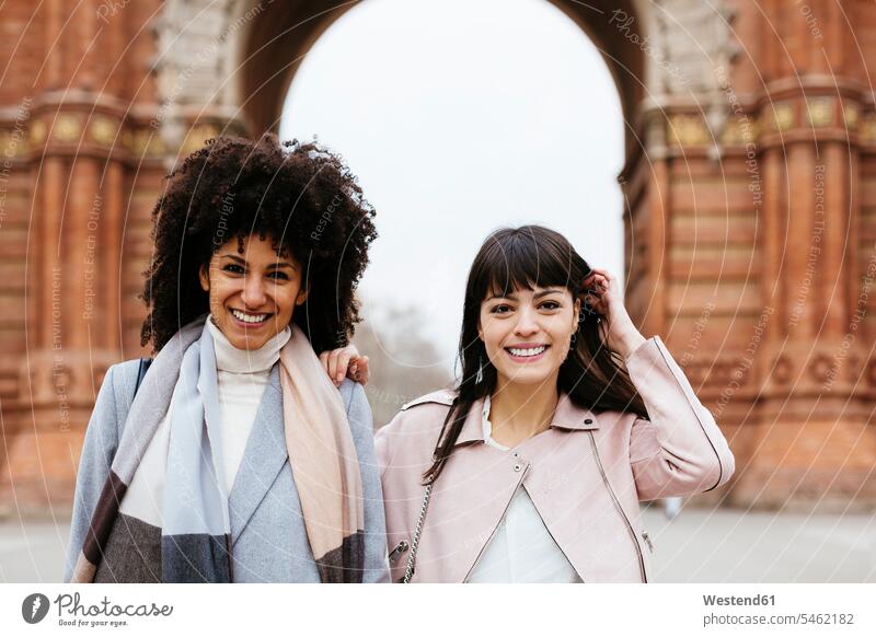 Spanien, Barcelona, Porträt von zwei glücklichen Frauen an einem Tor Portrait Porträts Portraits Glück glücklich sein glücklichsein Tore weiblich Freundinnen