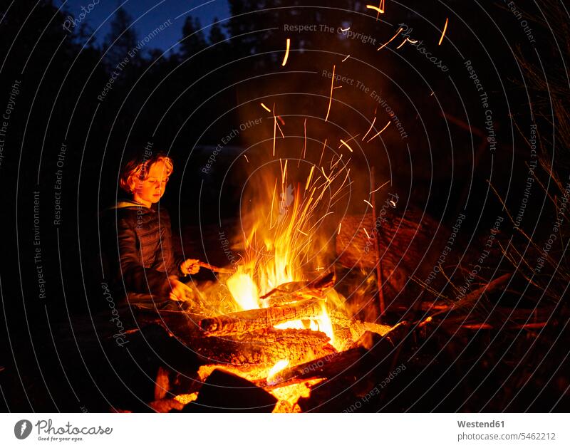 Argentinien, Patagonien, Lago Futalaufquen, Junge am Lagerfeuer bei Nacht nachts Buben Knabe Jungen Knaben männlich Feuer Kind Kinder Kids Mensch Menschen Leute